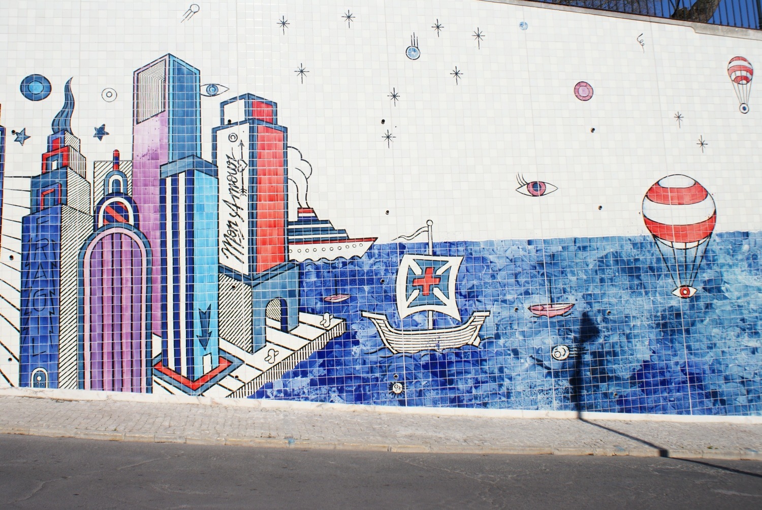 A caravel, a cruise ship and a striped hot air balloon on André Saraiva's tiled mural in Lisbon