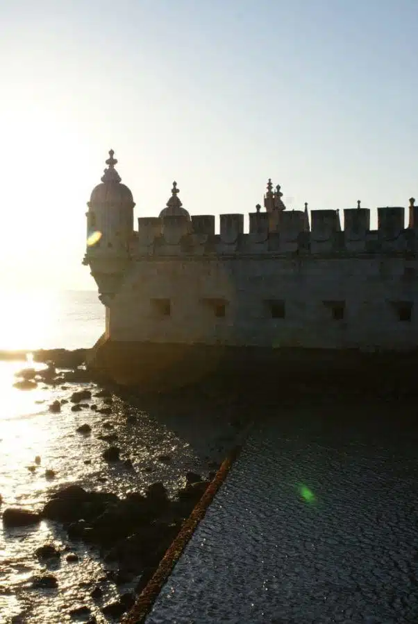 The Belém Tower silhouetted against low afternoon sun on the edge of the River Tagus, Lisbon
