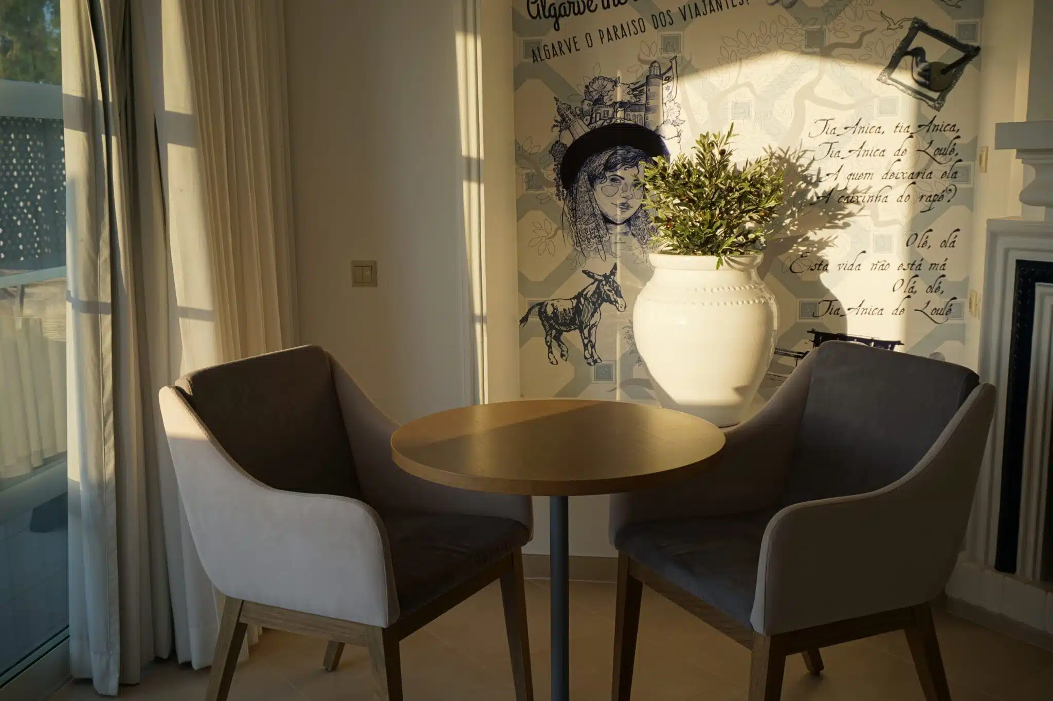 Round dining table, grey chairs and a painted feature wall in a renovated villa at Four Seasons Fairways