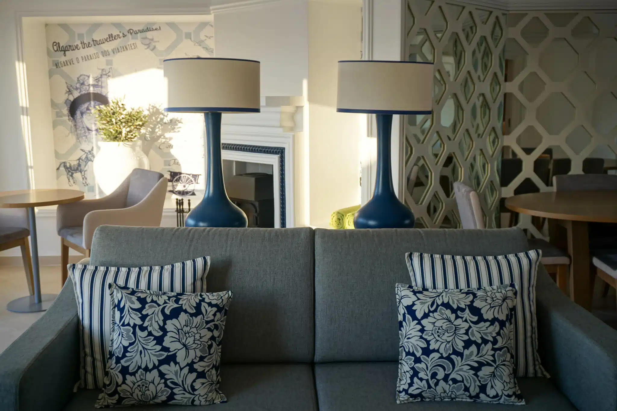 Grey sofa with blue patterned cushions and table lamps in a renovated villa living room at Four Seasons Fairways