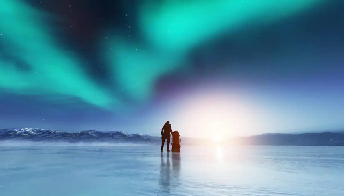 Man on lake with northern lights