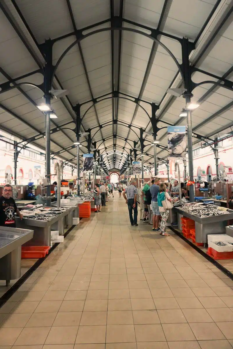 Fish and produce stalls running the length of the market hall in Loulé under its high iron roof