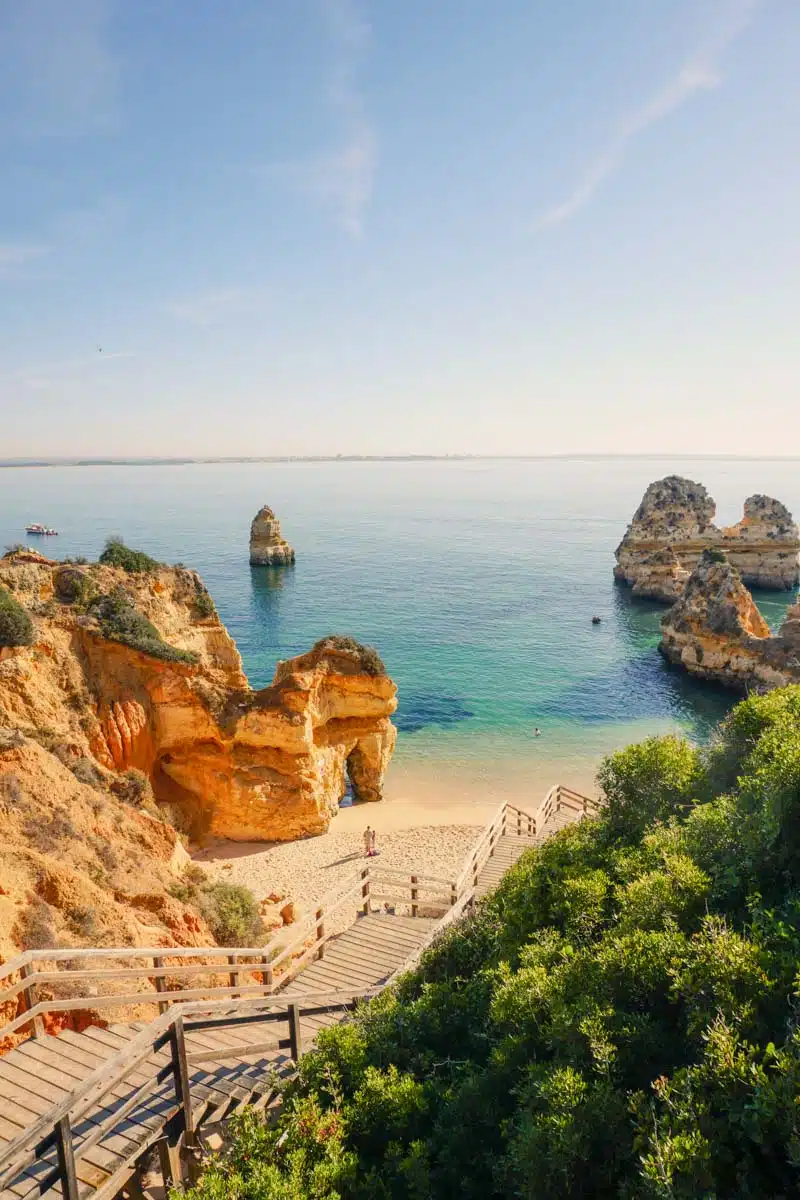 Praia do Camilo near Lagos from the clifftop, with its wooden staircase, golden rock stacks and calm turquoise sea