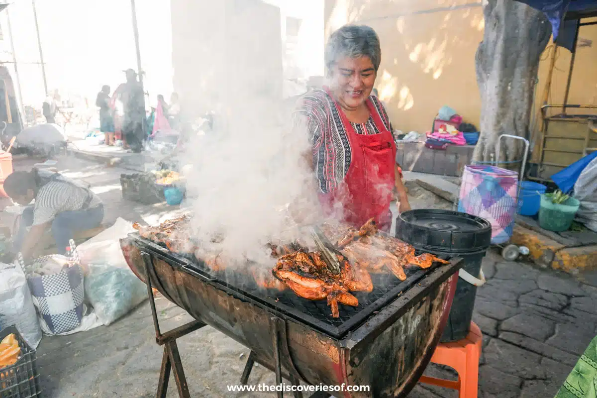 Woman cooking chickens at Tlacaloula 