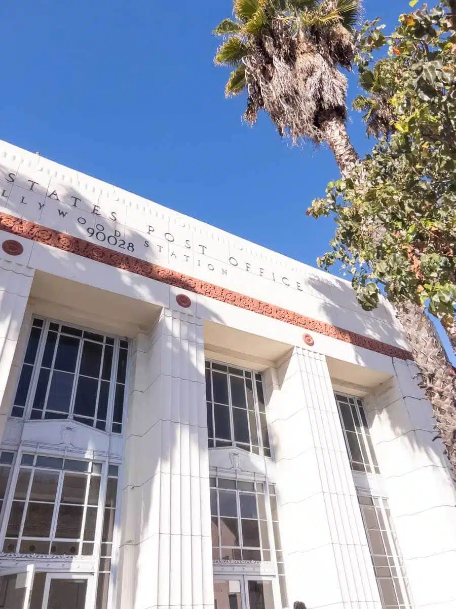 The white Art Deco facade of the 1937 Hollywood post office on Wilcox Avenue framed by palm fronds