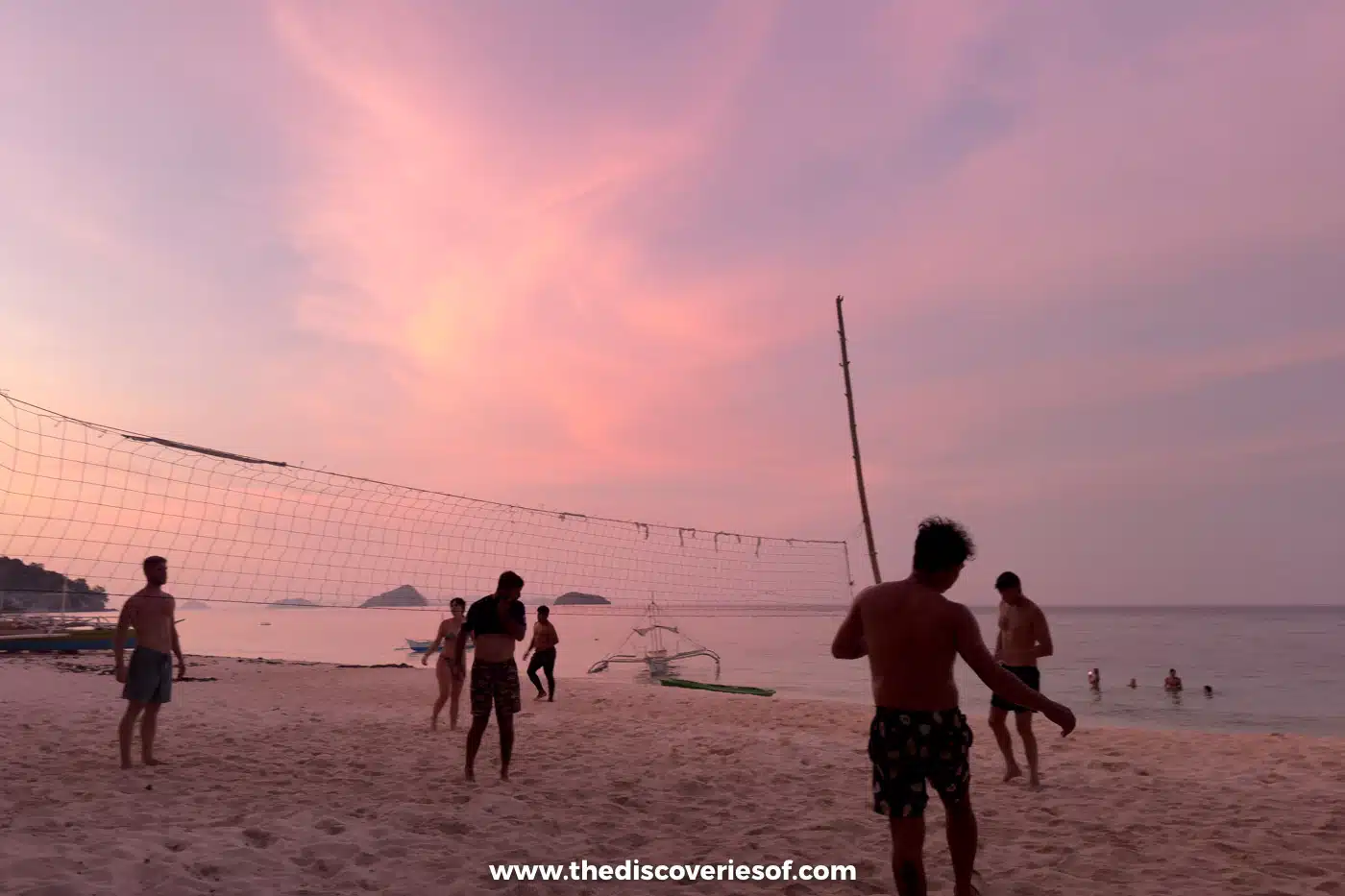 Playing beach volleyball at sunset
