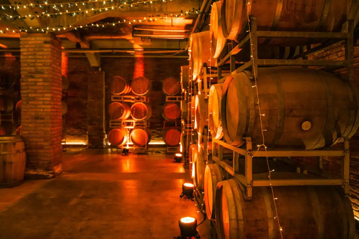 Barrel cellar at Casa Viñamar with brick pillars, fairy lights and orange uplighting, Casablanca Valley