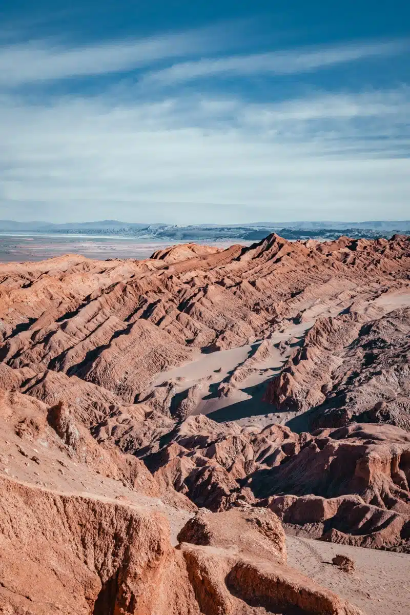 Eroded red and orange ridges of Ckamur stretching towards the horizon under a blue sky