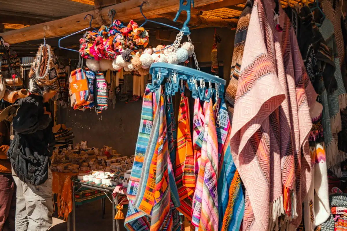 Colourful woven blankets, scarves and souvenirs hanging at a market stall in Colchani, Bolivia
