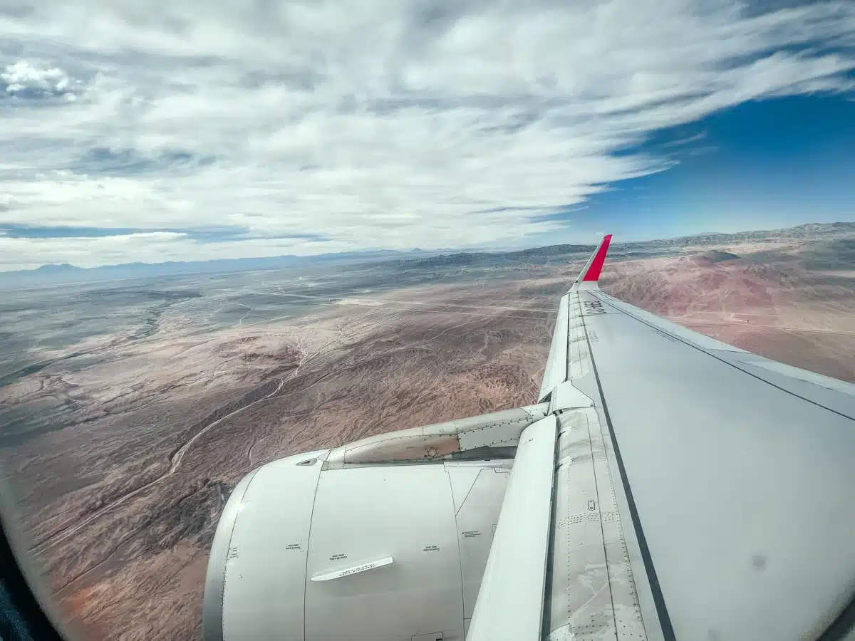 Aeroplane wing and engine over the brown Atacama Desert on the approach to Calama