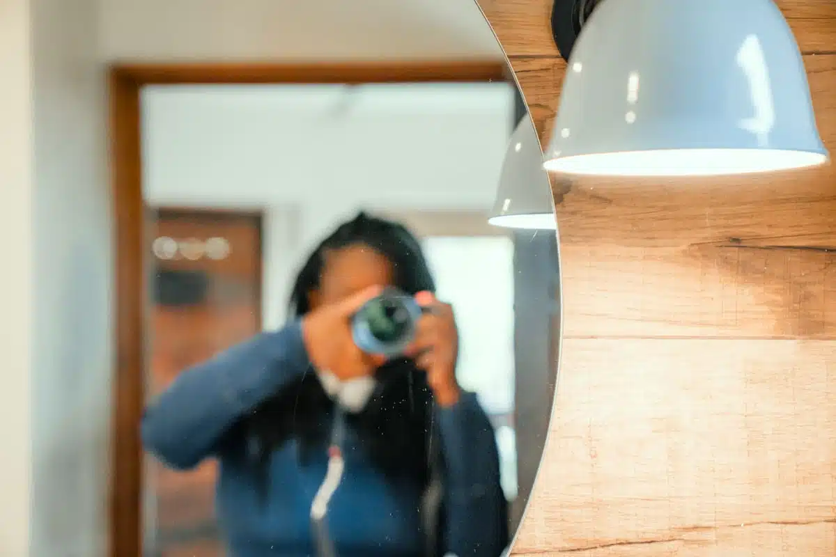 Julianna photographing her room at Hotel Desertica in a round mirror beneath a white pendant lamp