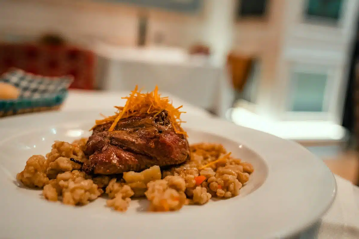Grilled fillet on a bed of risotto-style grains topped with crispy shallots at Liguria