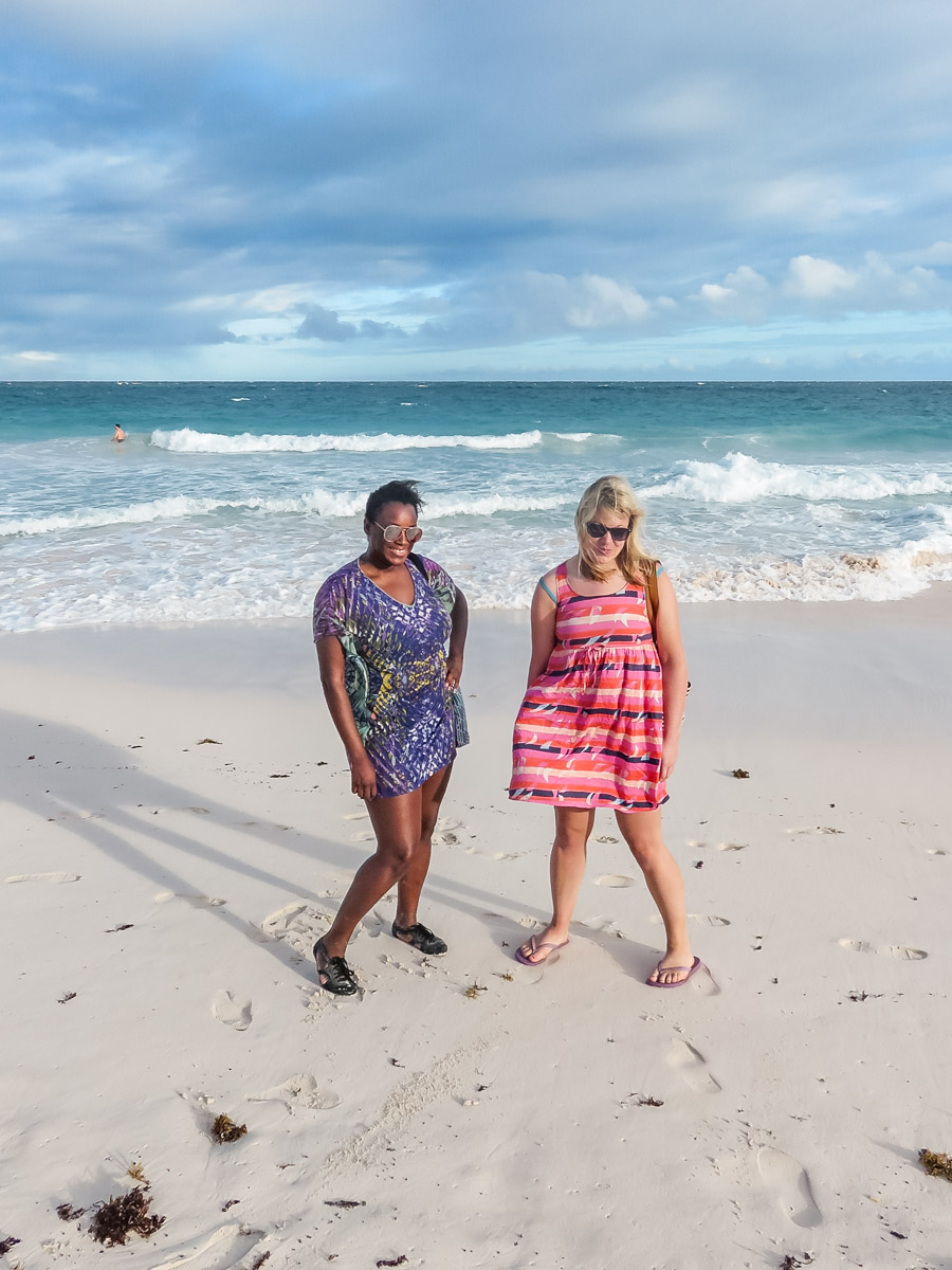 Two women standing on the pink sand of Crane Beach below The Crane hotel in Barbados