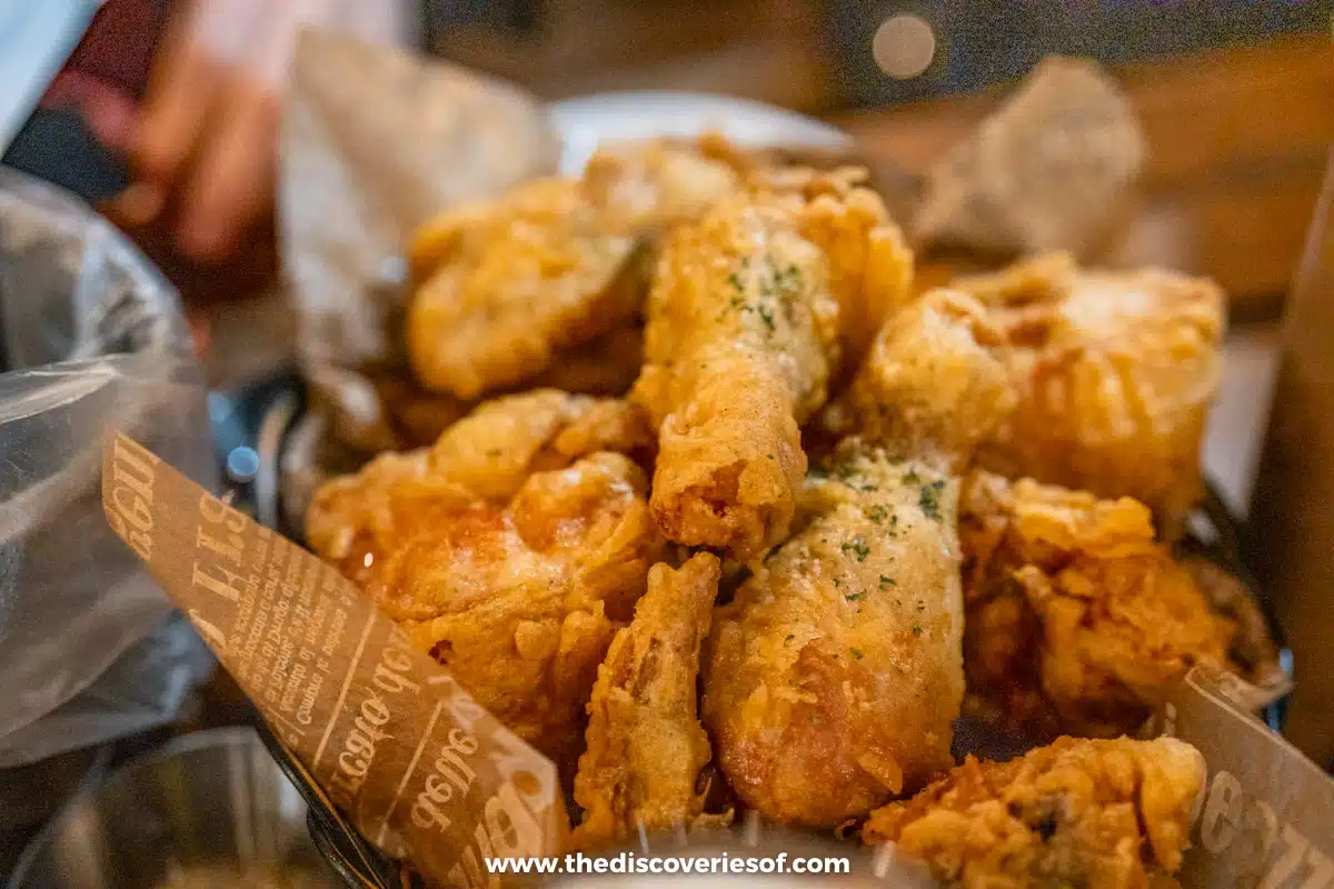 Pieces of golden Korean fried chicken in a basket lined with printed paper at a restaurant in Mokpo