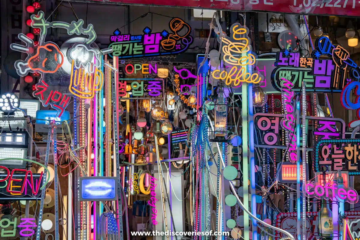 A shopfront covered in colourful neon signs and lights in Seoul