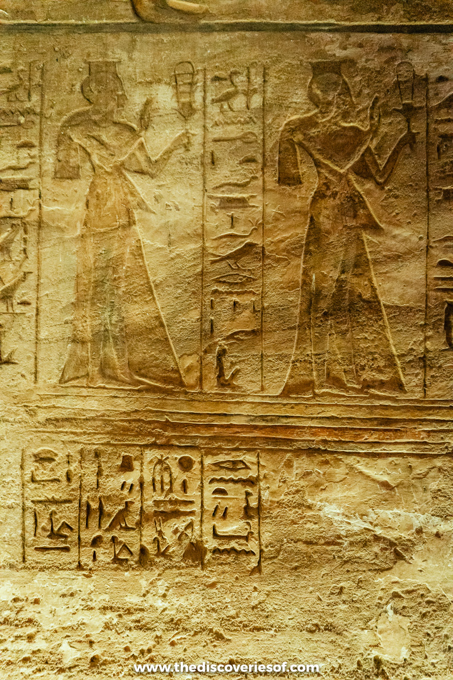 Wall relief of two royal women in long dresses holding sistrums above hieroglyphs, Great Temple, Abu Simbel
