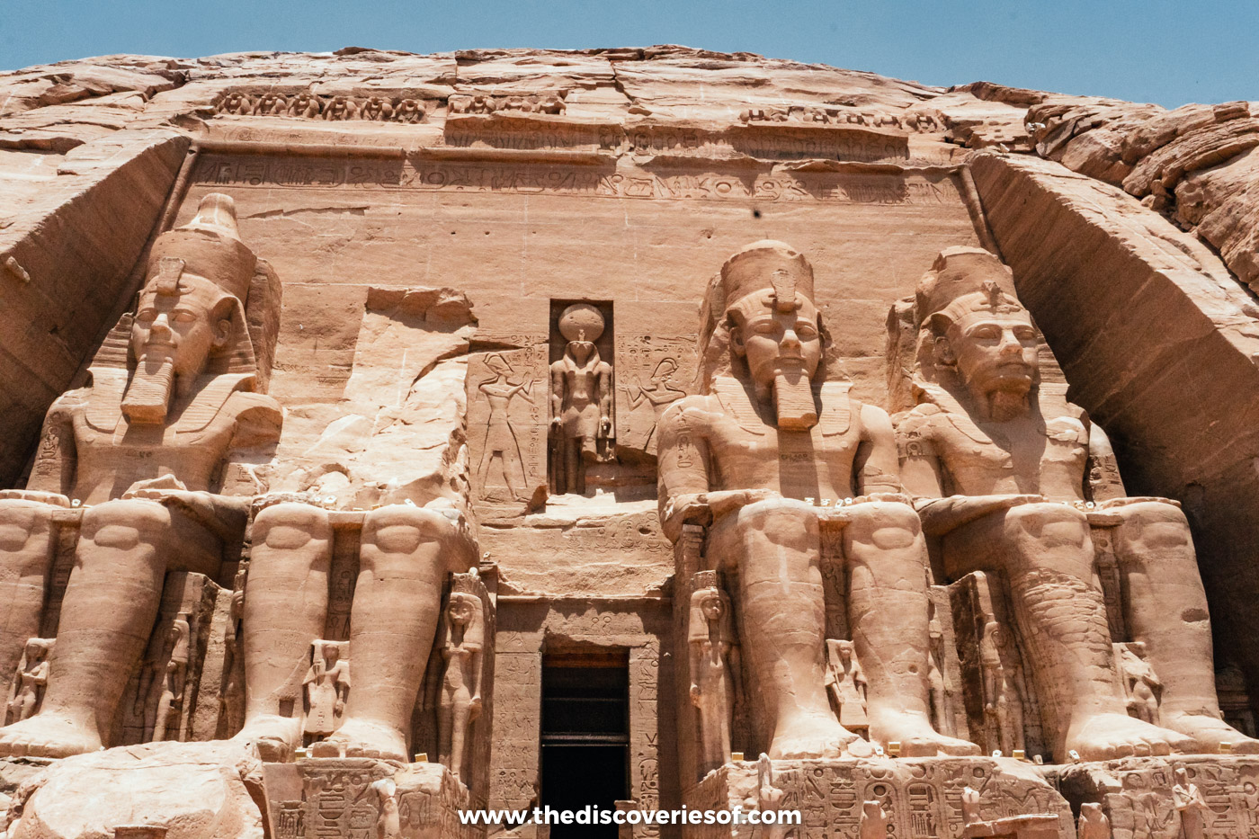 The facade of the Great Temple at Abu Simbel, with one colossus broken and its head lying below