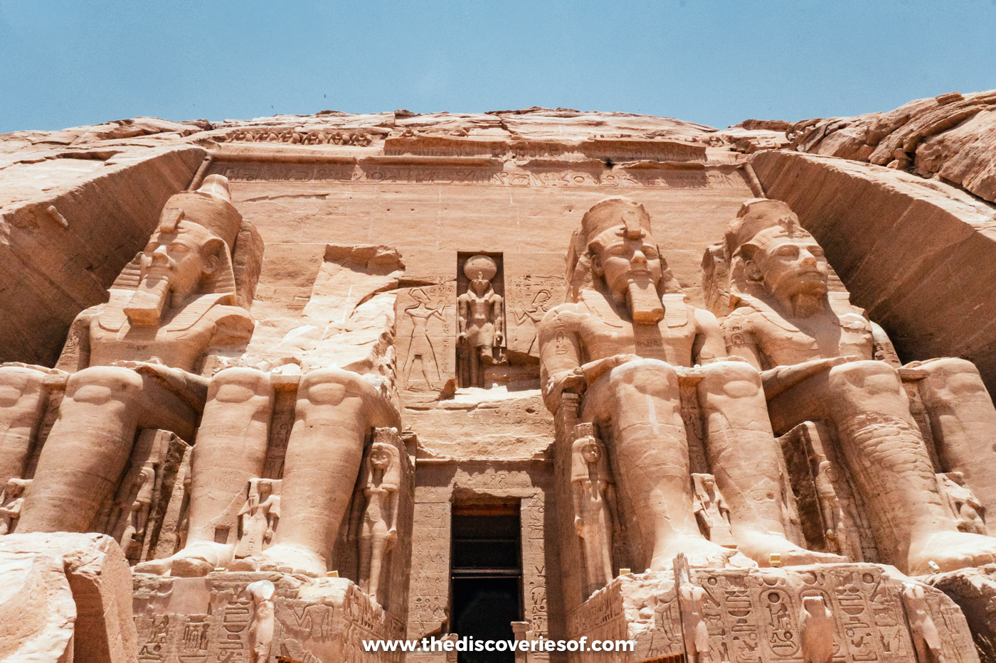 The doorway of the Great Temple at Abu Simbel between colossi, with falcon-headed Ra-Horakhty in a niche above