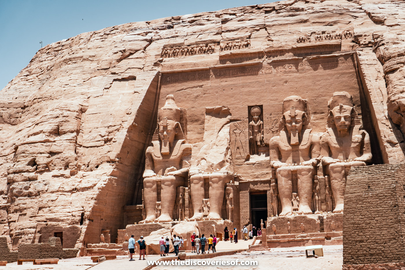 Visitors gathered in front of the rock-cut facade and four colossi of the Great Temple of Ramses II, Abu Simbel