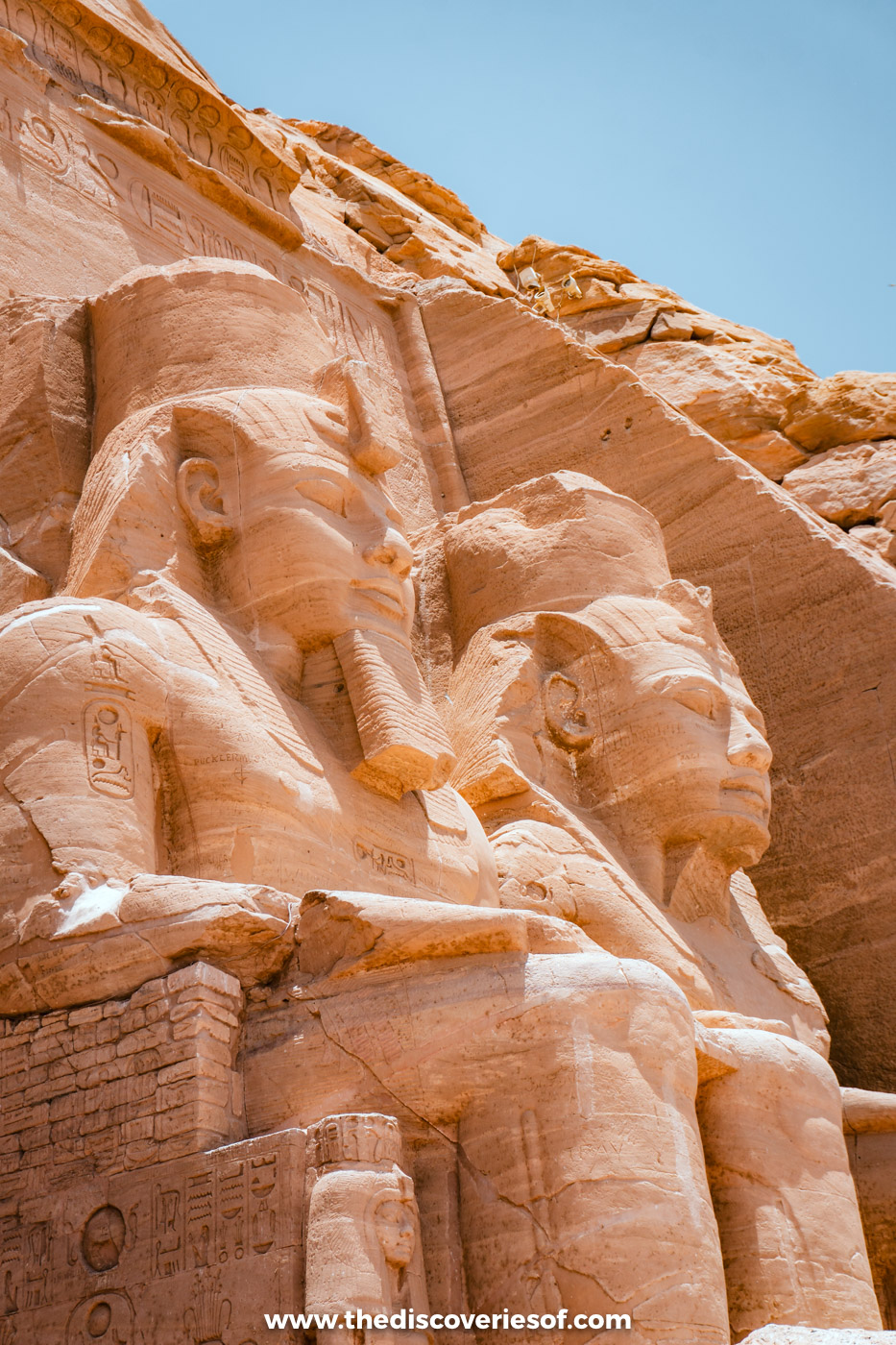 Two seated colossi of Ramses II in the double crown, seen from the side against a blue sky, Abu Simbel