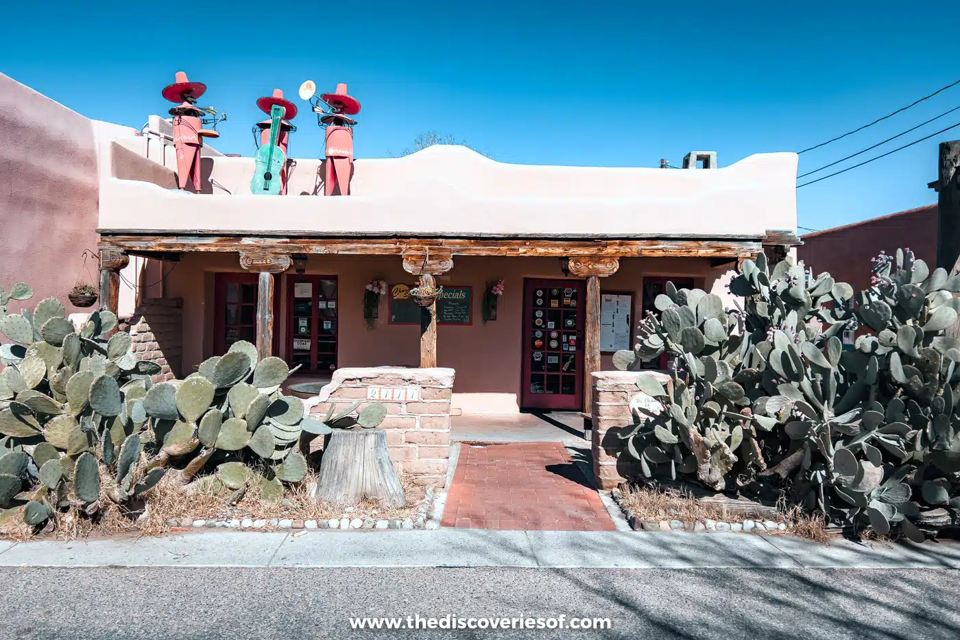 Adobe building with prickly pear cacti and a brick path in Old Town Albuquerque