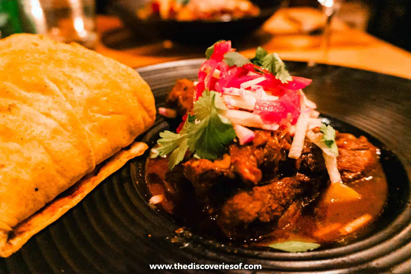 Braised lamb birria topped with pickled onion and herbs, with a tortilla, at Campo, Los Poblanos