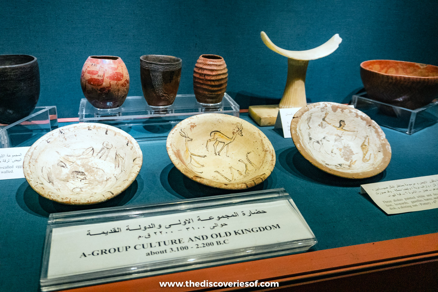 A-Group pottery, painted bowls and a carved headrest in a display case at the Nubian Museum, Aswan