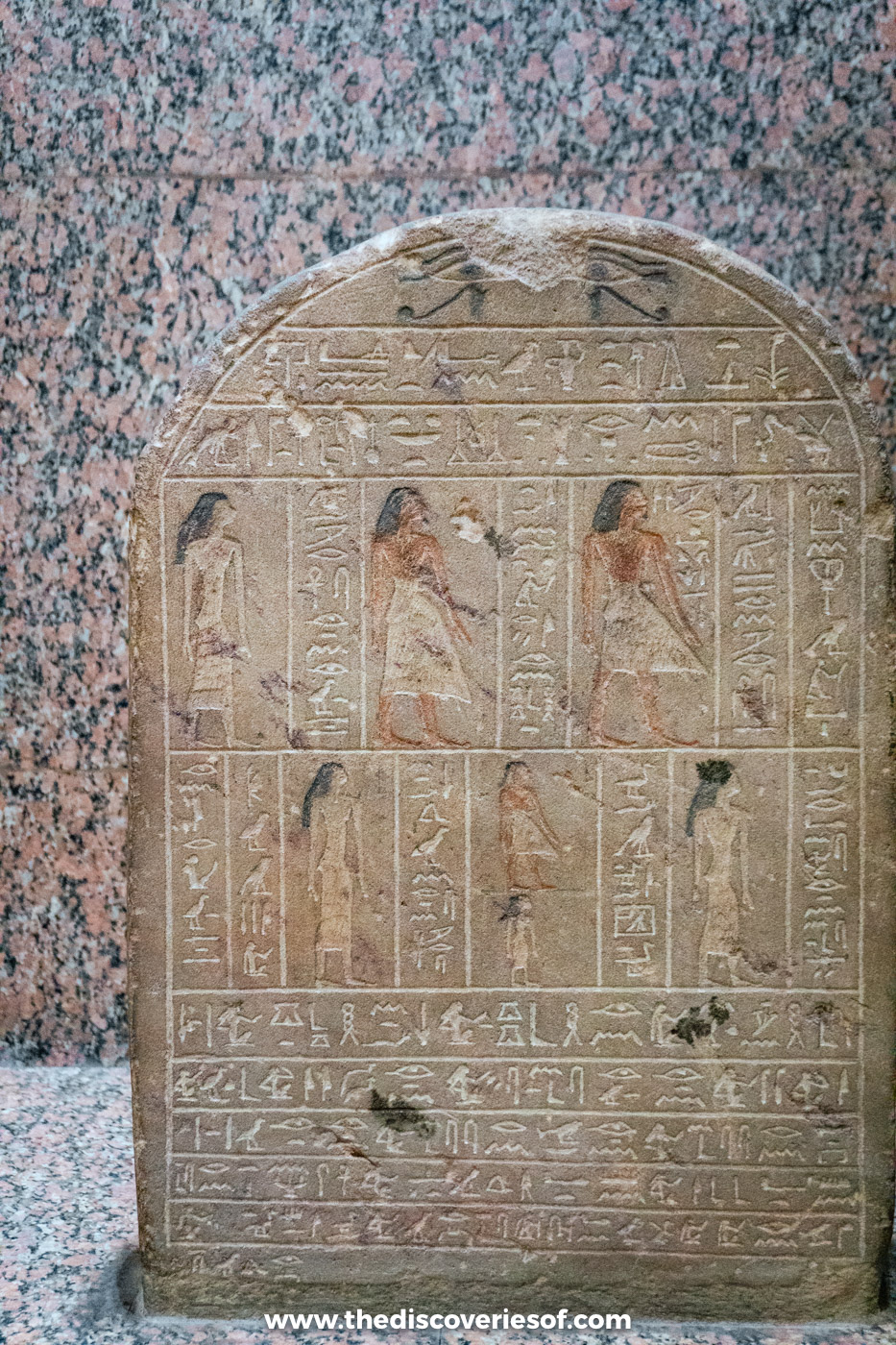 An ancient Egyptian stone stela carved with rows of standing figures and hieroglyphs in the Nubian Museum