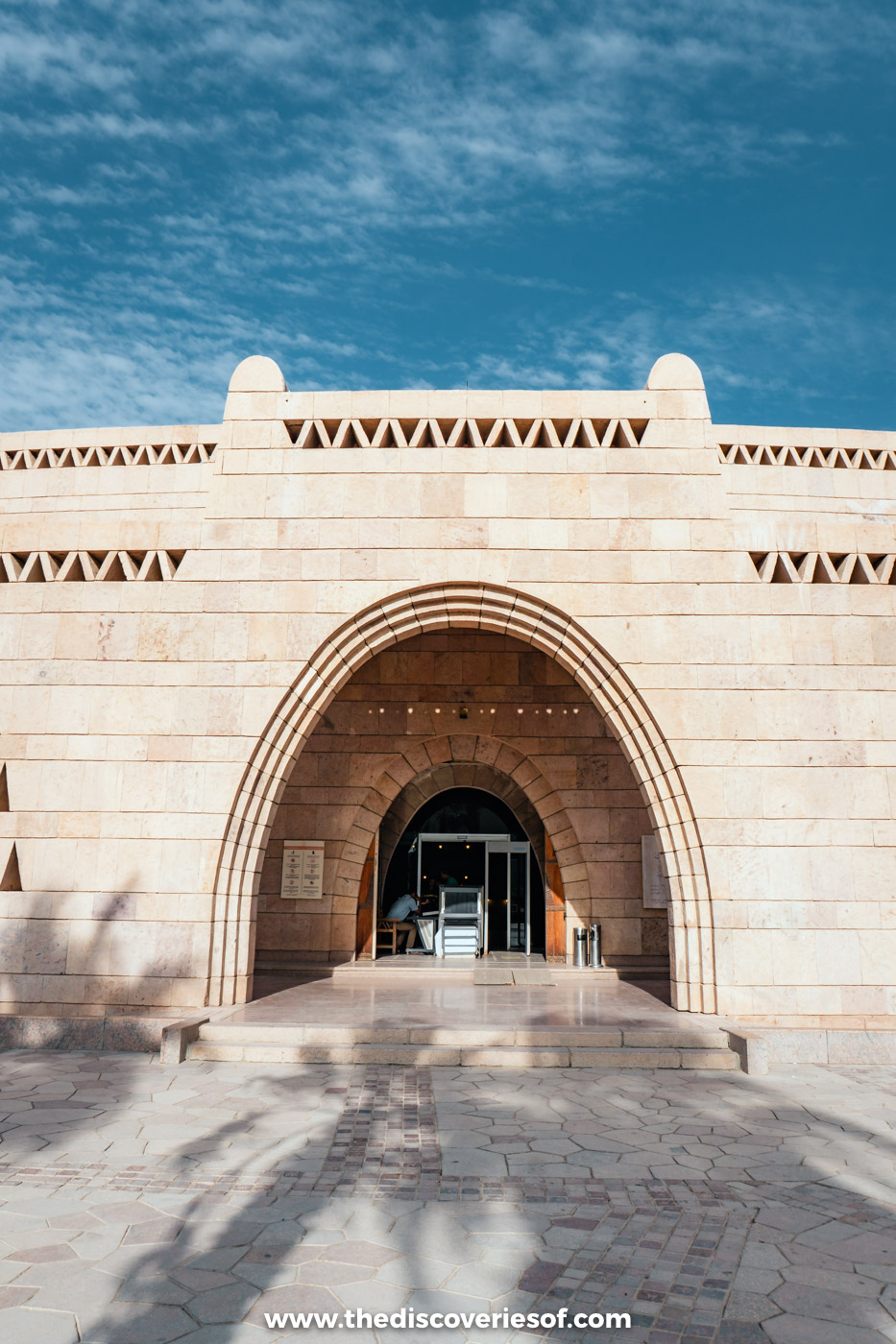 The arched sandstone entrance of the Nubian Museum in Aswan, decorated with Nubian geometric patterns