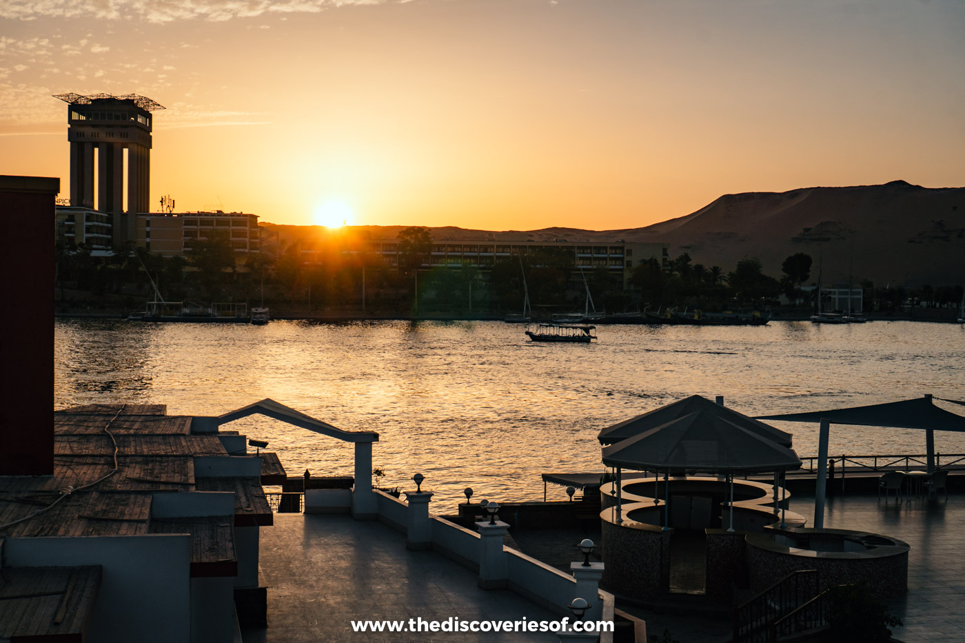 The sun setting over the Nile and the West Bank hills, seen from a riverside terrace in Aswan