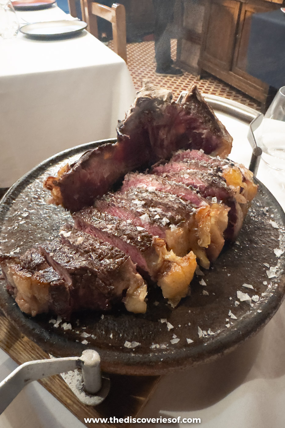 Sliced txuleta rib steak with sea salt on a hot stone plate at Casa Rufo, Bilbao