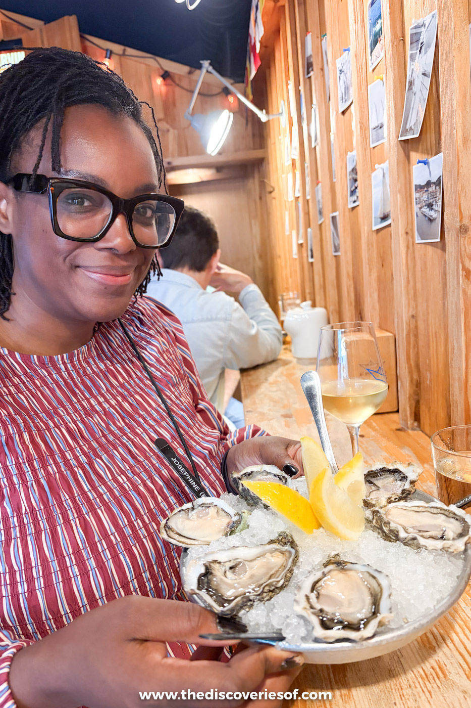 Julianna smiling with a plate of fresh oysters on ice and lemon at El Puertito oyster bar in Bilbao