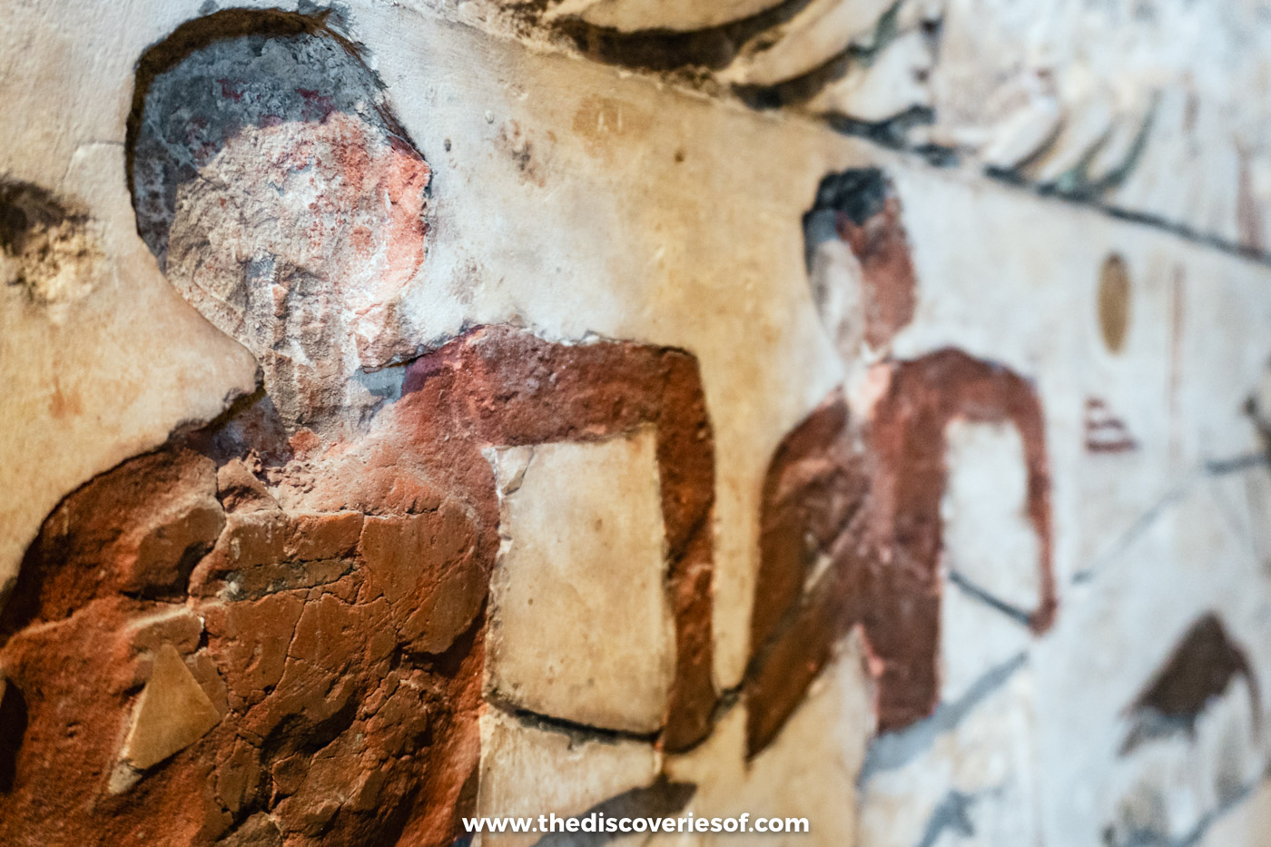 A painted limestone relief of figures with traces of red pigment in the Egyptian Museum in Cairo