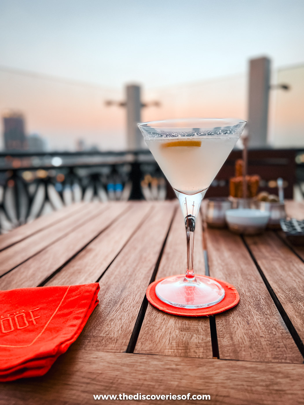A cocktail on a wooden table on the rooftop terrace of the Kempinski Nile Hotel in Garden City