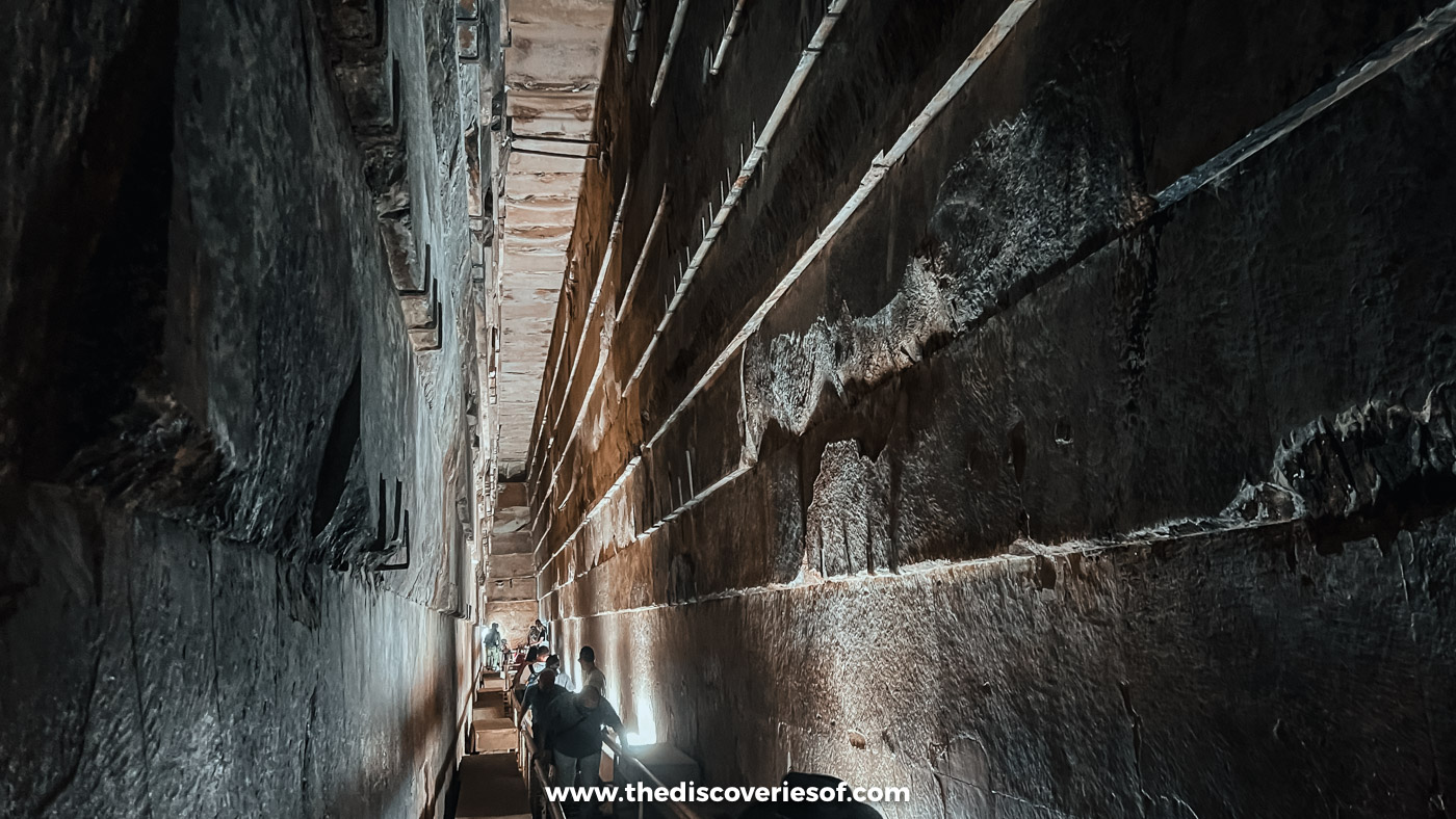 The tall corbelled stone walls and wooden ramp of the Grand Gallery inside the Great Pyramid of Giza