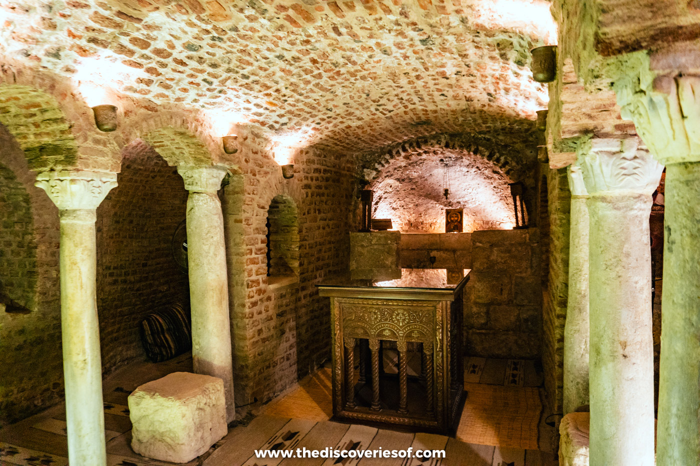 The vaulted crypt with stone columns and a small wooden altar beneath the Church of St Sergius and St Bacchus