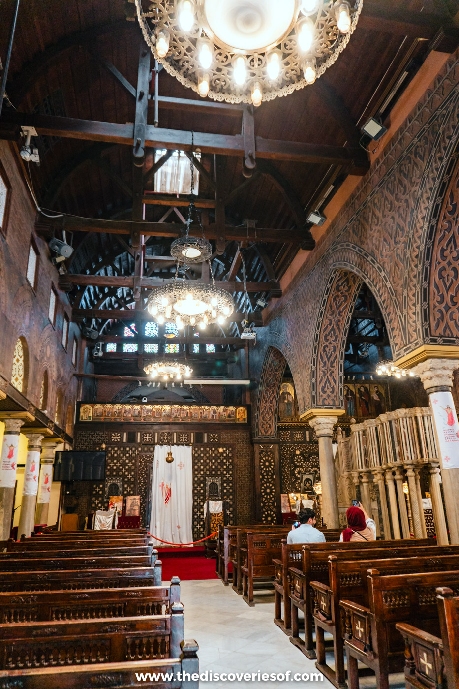 Wooden pews, chandeliers and the timber roof of the nave inside the Hanging Church in Coptic Cairo