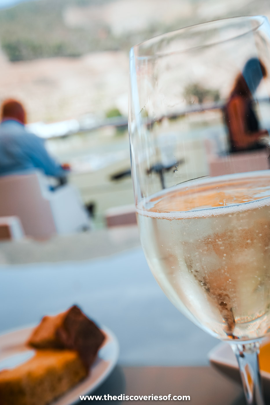 A glass of sparkling wine and a slice of cake on the riverside terrace at DOC restaurant in the Douro Valley