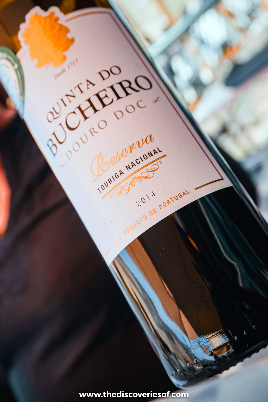 A bottle of Quinta do Bucheiro Douro red wine held up at the table at DOC restaurant in the Douro Valley