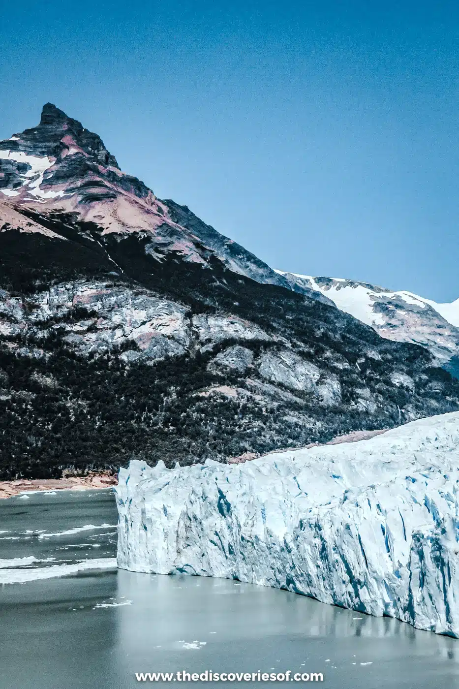 Perito Moreno Glacier's ice front rising from Lago Argentino below a jagged rocky peak, Argentina