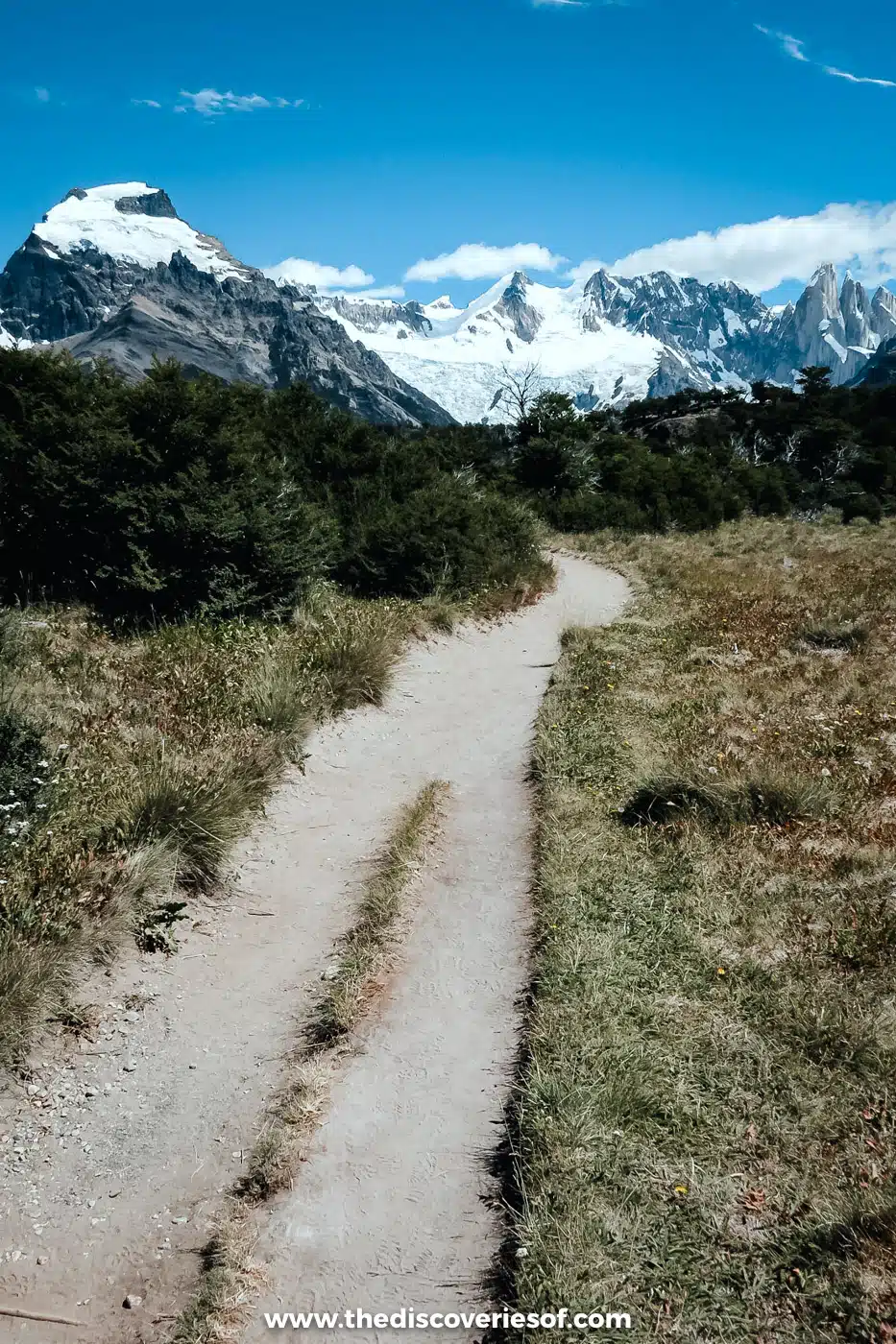 Dirt path through scrub towards snowy peaks on the Laguna Torre trail, El Chaltén