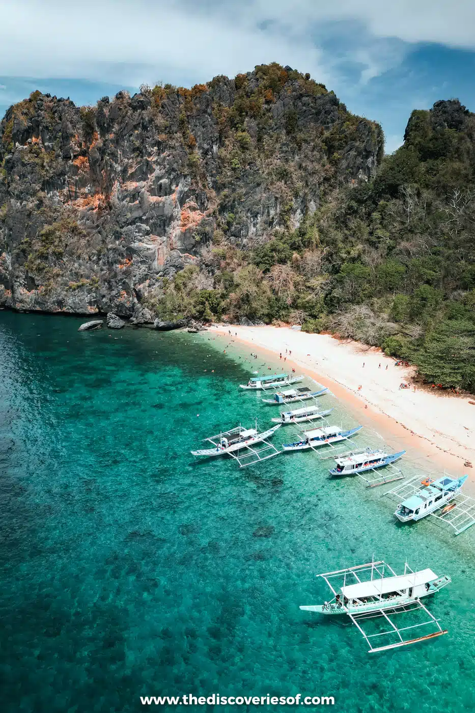 Aerial view of bangka boats lined up off the white beach at Helicopter Island, El Nido