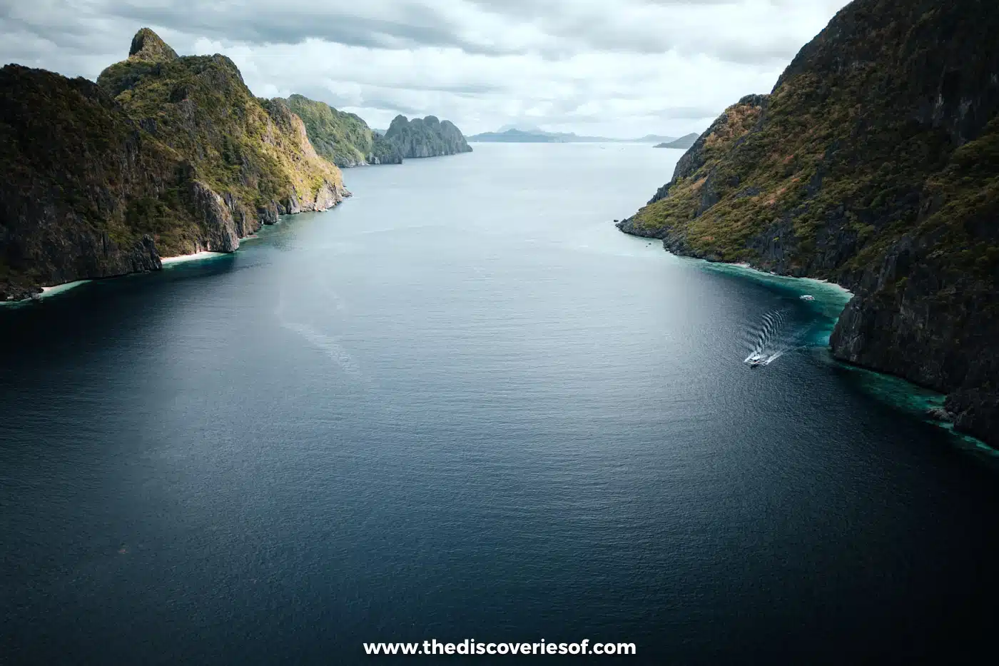 Aerial view of a calm channel between steep limestone islands on the edge of Bacuit Bay, El Nido