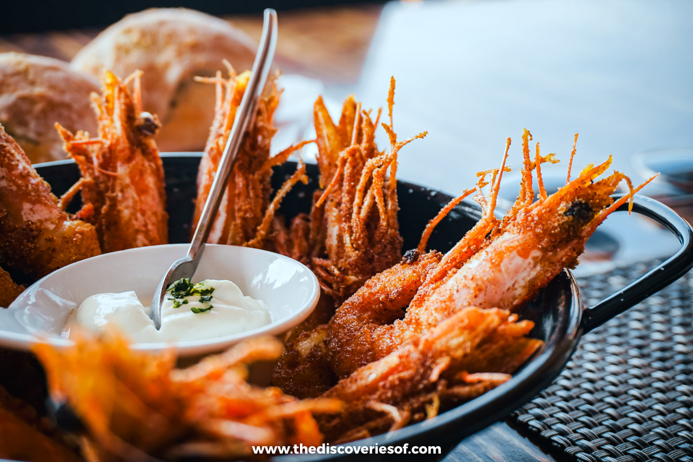 Whole crispy fried prawns piled in a pan around a small bowl of creamy dip at Estaminé on Ilha Deserta