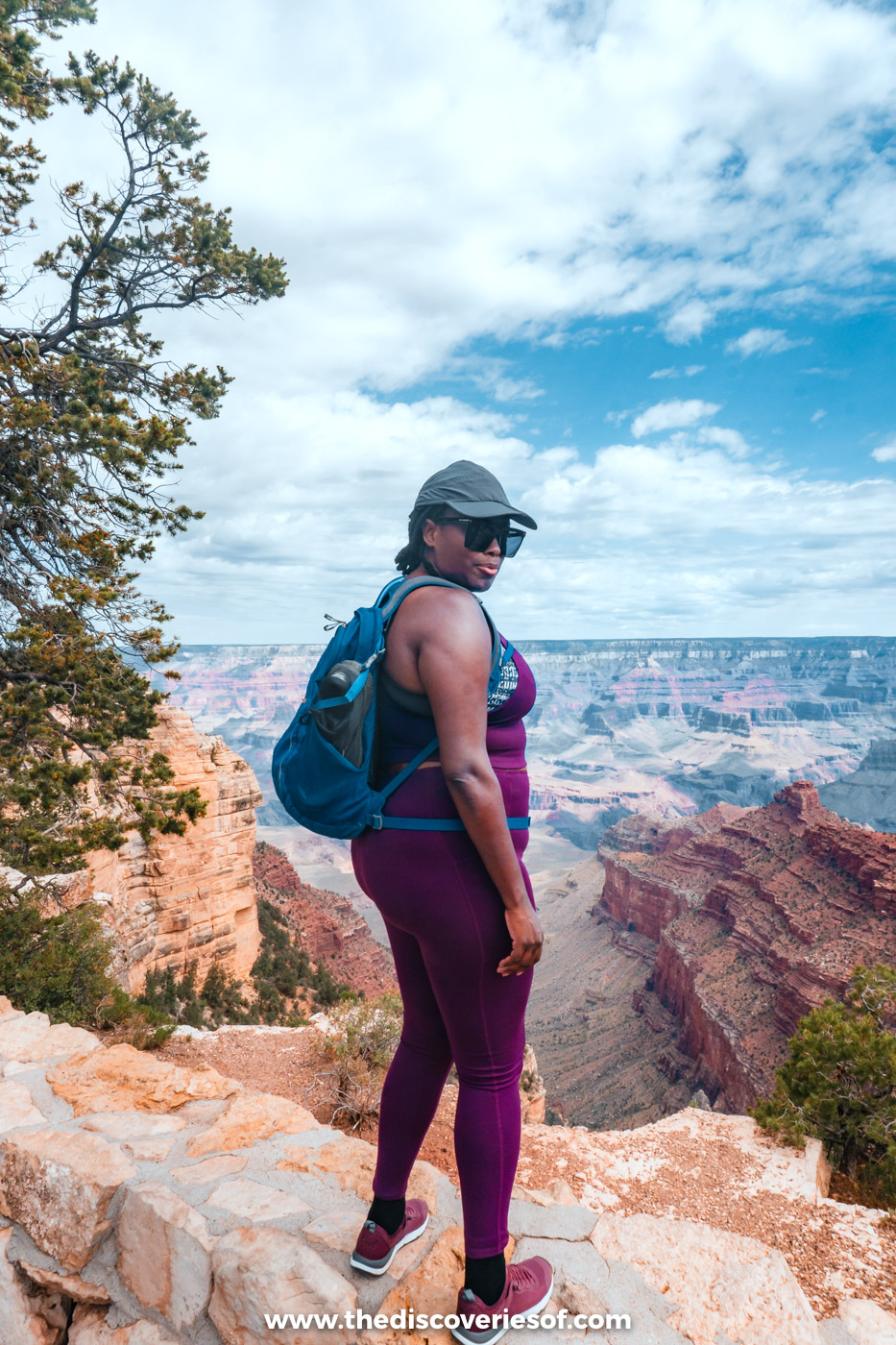 Julianna standing on a rocky outcrop on the South Rim of the Grand Canyon, looking out over the canyon