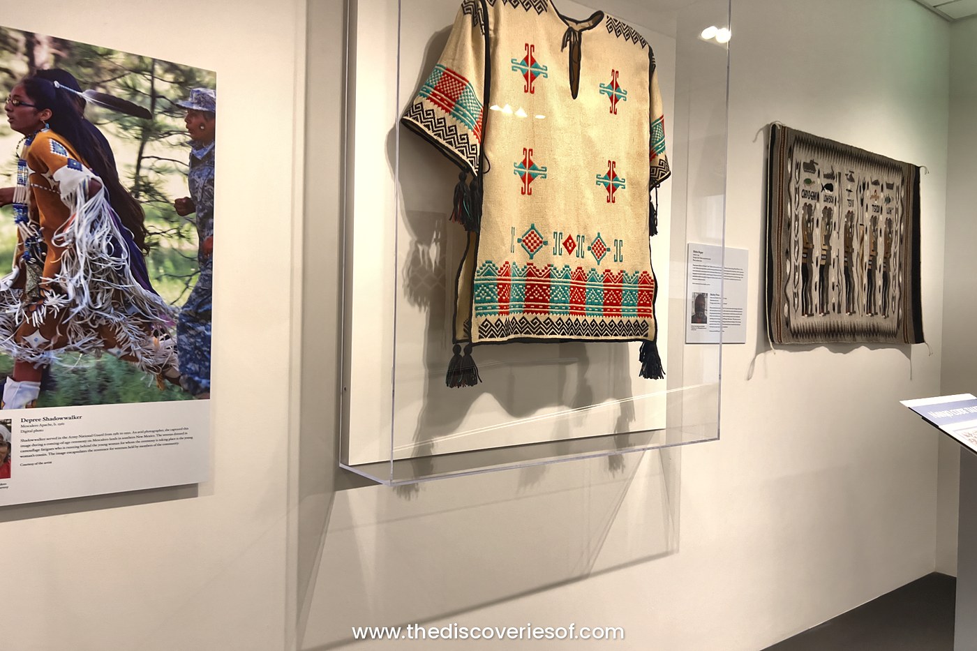 Gallery at the Heard Museum in Phoenix with a woven shirt, a woven rug and a large portrait of a dancer