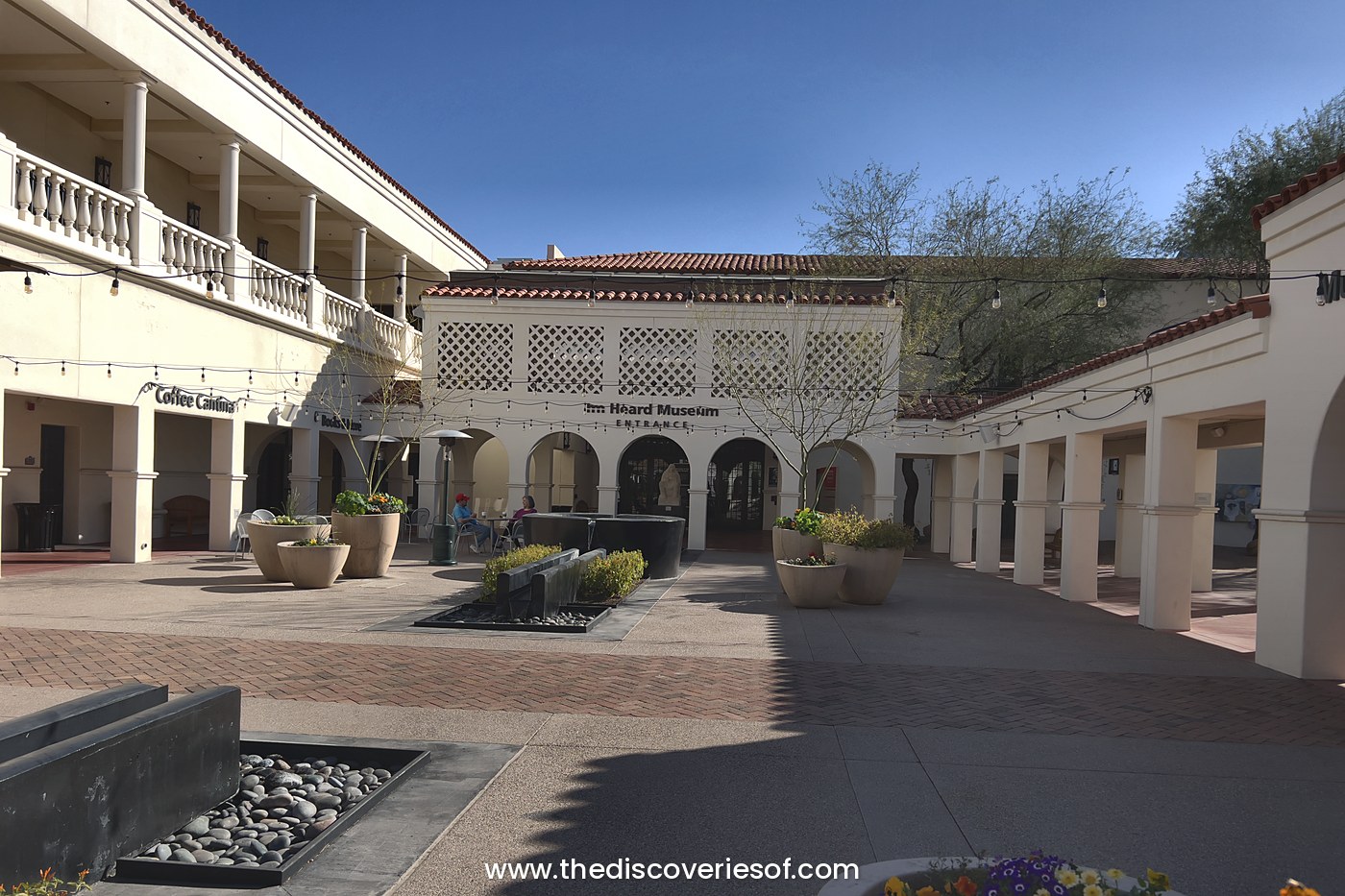 The courtyard and arched entrance of the Heard Museum in Phoenix, Arizona, under a clear blue sky