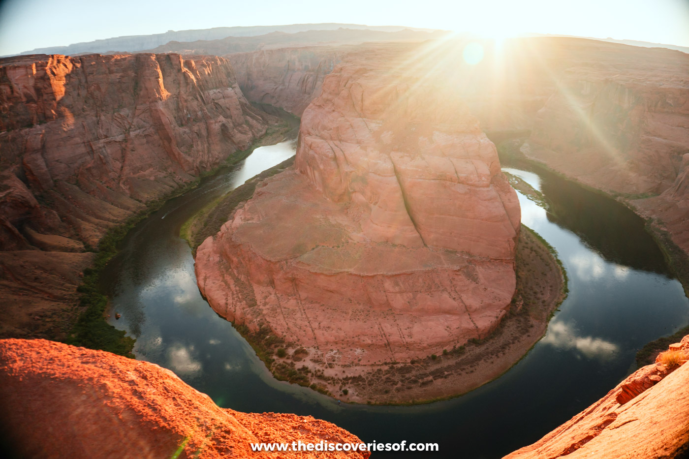 The Colorado River curving around the sandstone dome of Horseshoe Bend near Page as the sun sets