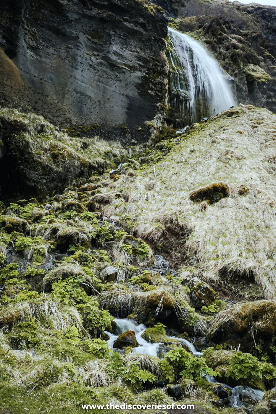 A small waterfall trickling over moss-covered rocks on the cliff walk between Seljalandsfoss and Gljúfrabúi