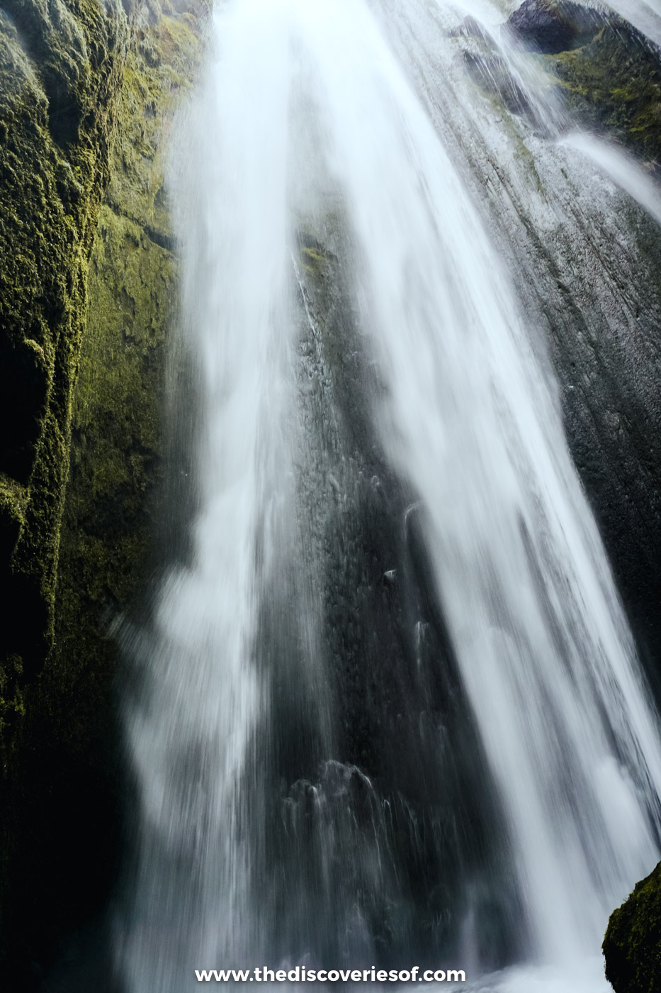 Gljúfrabúi waterfall dropping down mossy rock walls inside its narrow gorge near Seljalandsfoss